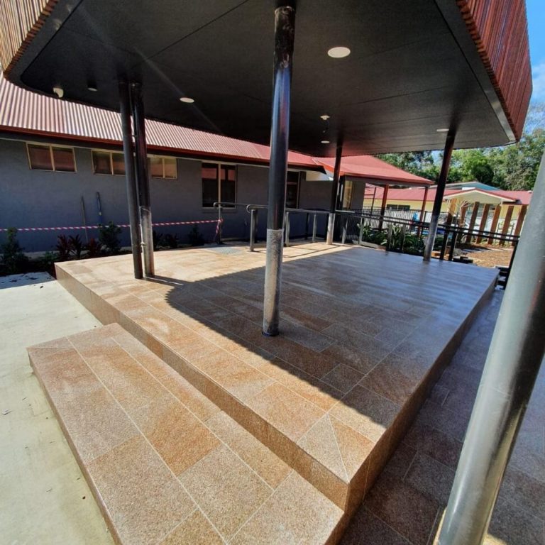 A covered patio with steps and sealed tiles.