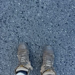 Point of view of a person's feet standing on a epoxy flooring surface.