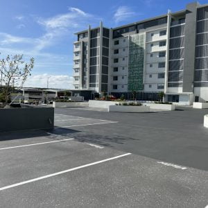 A freshly finished parking lot in front of an apartment building.