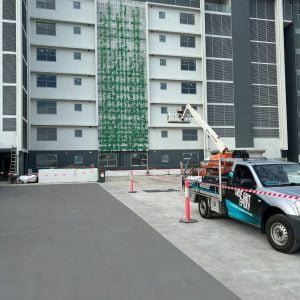 True Grit vehicle is parked in front of an apartment building.