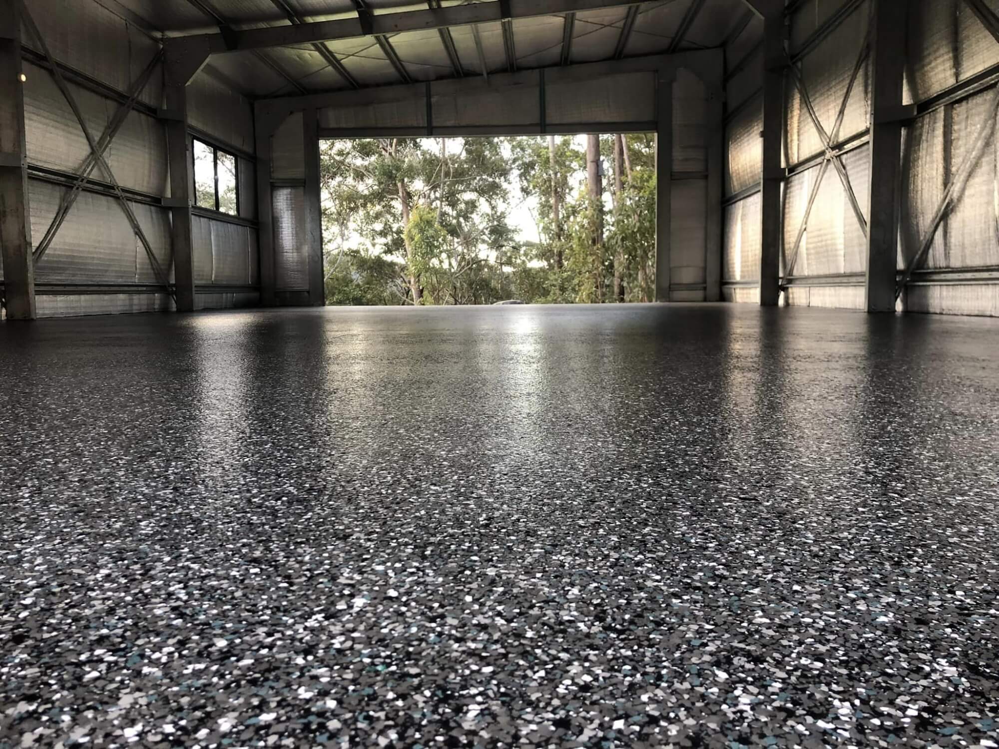 Close up on the freshly finished flake epoxy flooring of a shed.