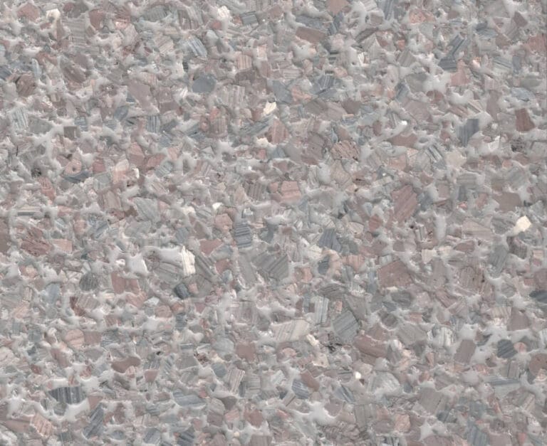 Close-up of a textured surface with a mosaic pattern of irregular, multicolored stone fragments in shades of gray, pink, and white.