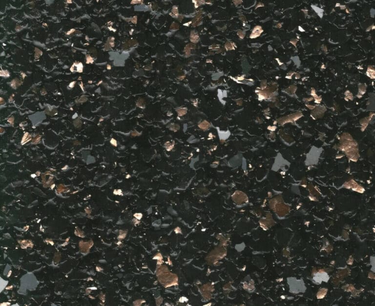 A close-up of a dark green textured surface with scattered irregular brown and black fragments.