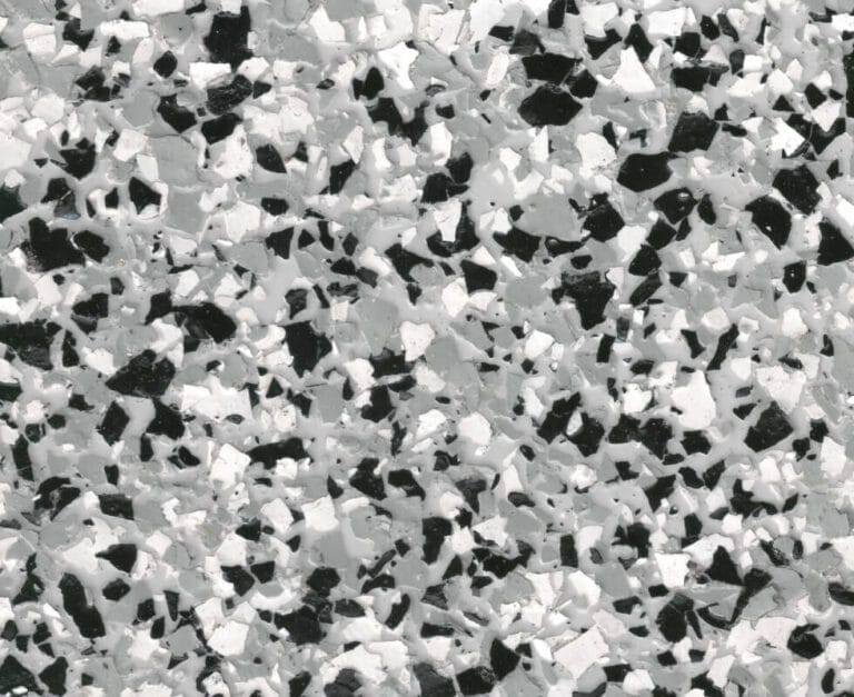 Black, white, and gray speckled terrazzo surface, featuring irregularly shaped chips embedded in a smooth background.