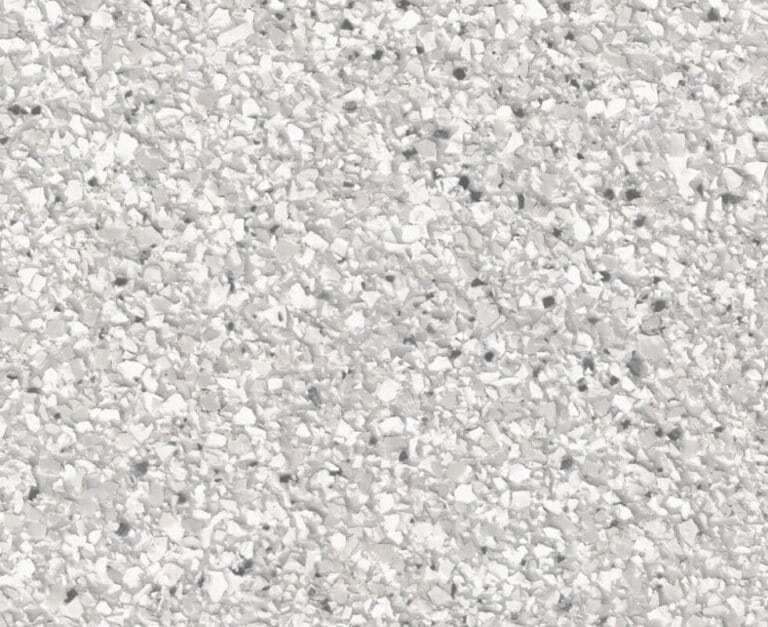 A textured surface with small, irregular white and gray pebble-like patterns. The overall appearance is granular and rough.