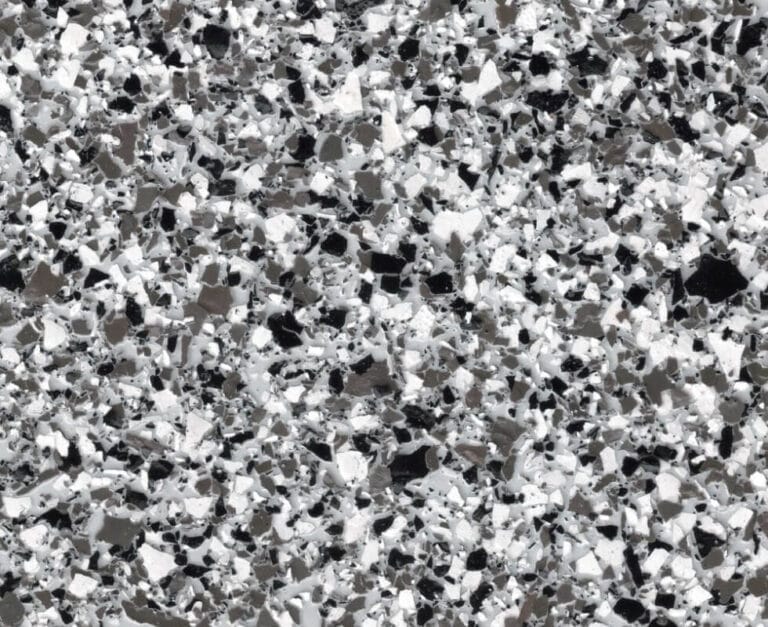 Close-up of a speckled black, white, and gray terrazzo surface, showing irregularly shaped chips embedded in a smooth matrix.