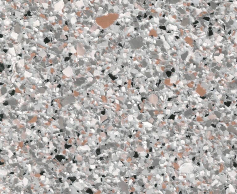 Close-up of a terrazzo floor with a mix of gray, white, and beige marble chips embedded in a light gray cement background.