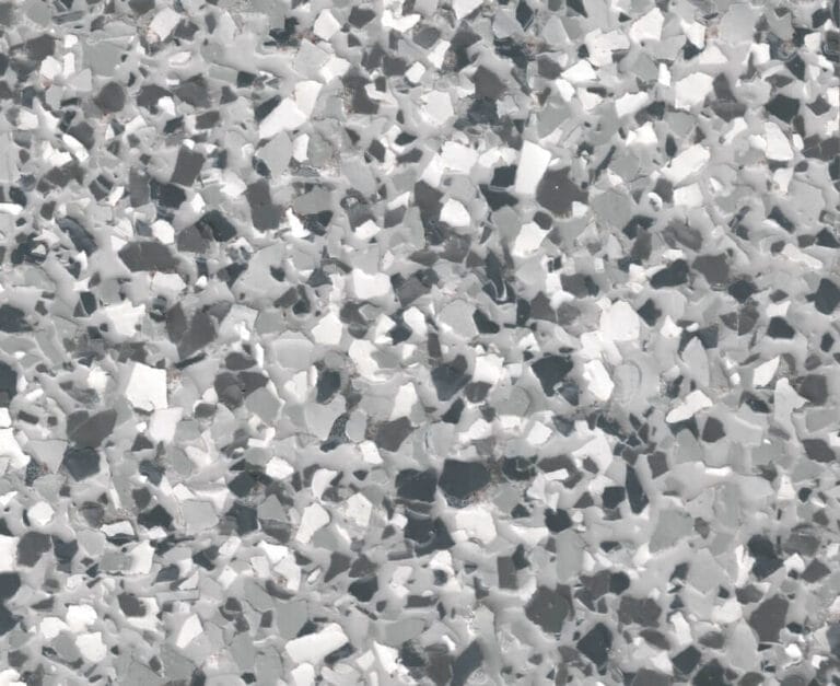 A close-up view of a gray and white terrazzo pattern with irregularly shaped chips embedded in the surface, creating a speckled appearance.