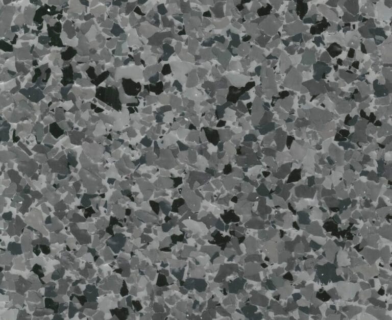 Close-up of a terrazzo surface with a mix of gray, black, and white stone fragments embedded in a smooth matrix.